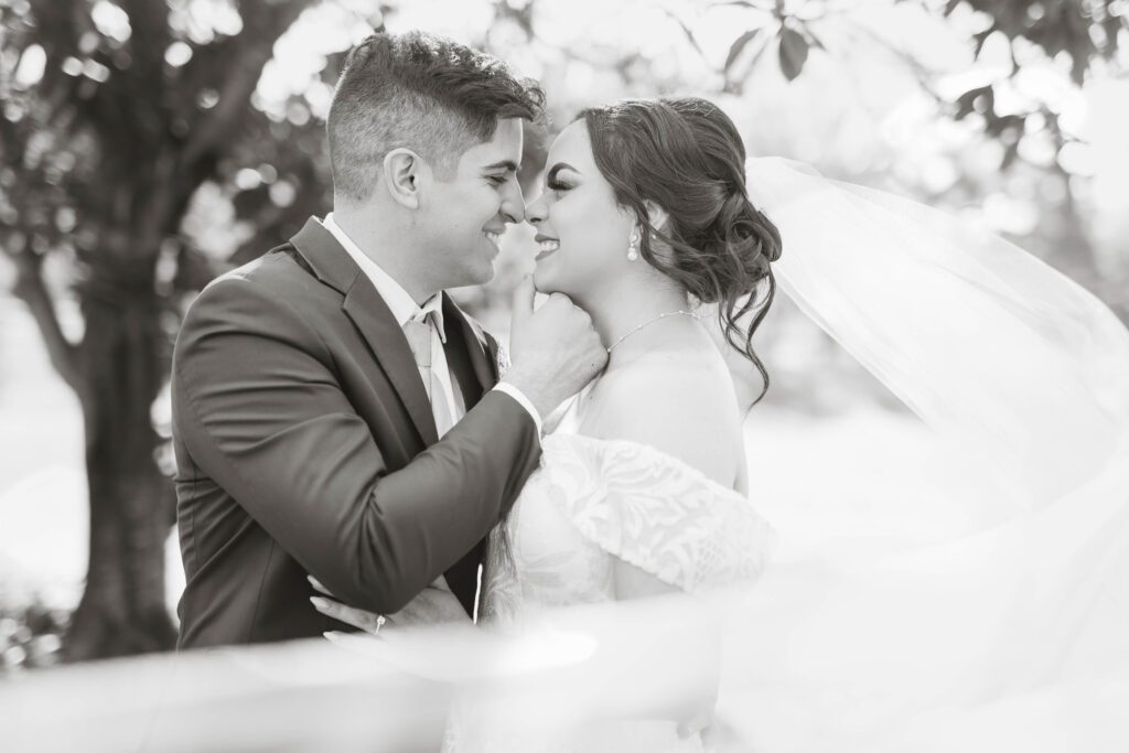 Wedding couple embrace, grinning ear to ear in a timeless black and white photo